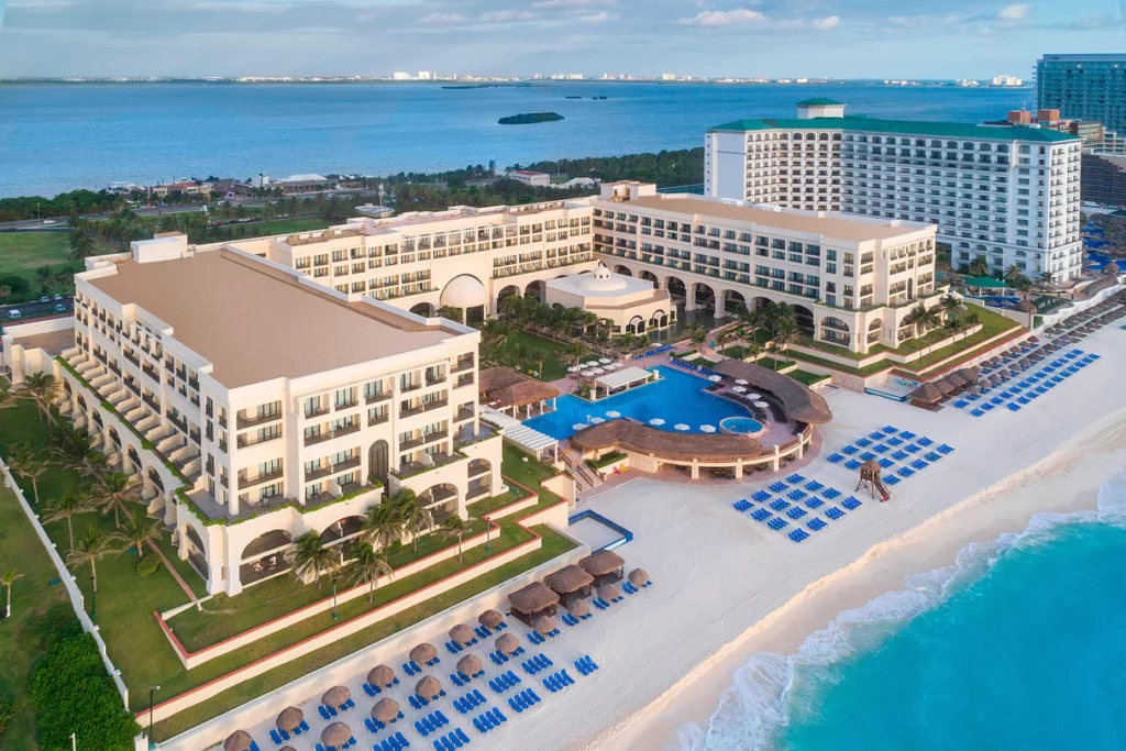 a large hotel with a pool and a beach