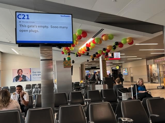 a group of people sitting in chairs in an airport