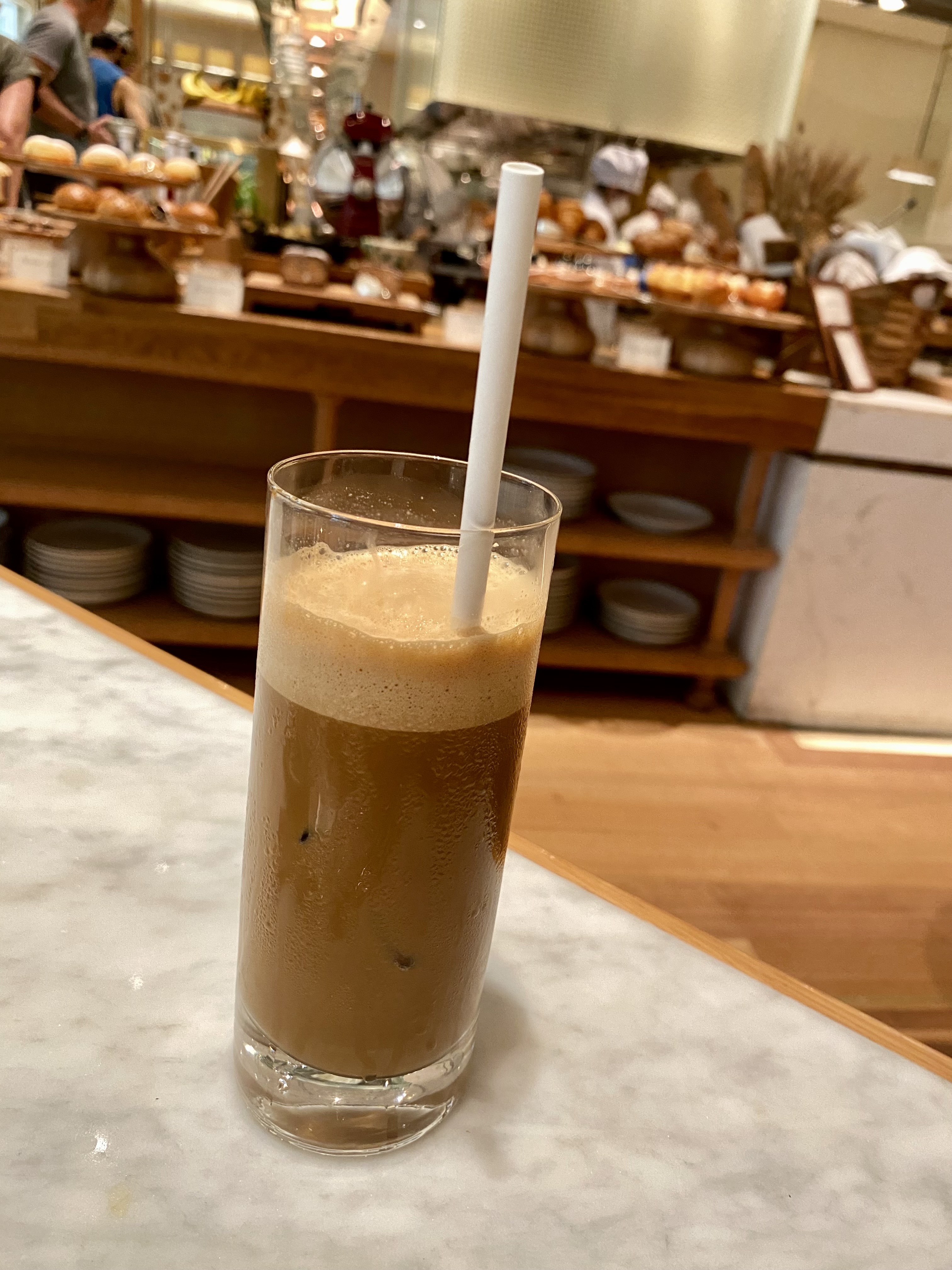 a glass of coffee with a straw