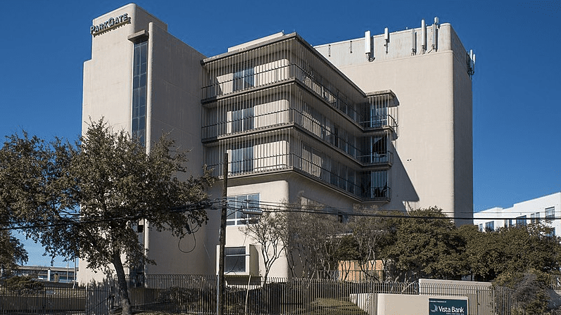 a building with a fence and trees