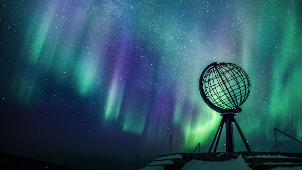 a globe and aurora borealis in the sky