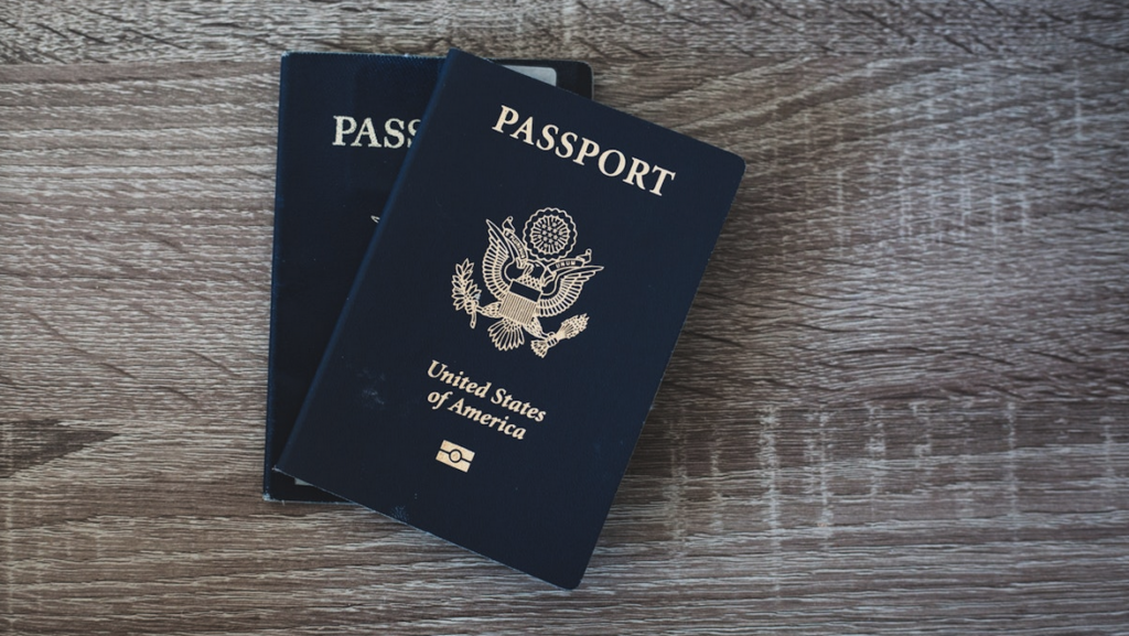 two blue passports on a wooden surface