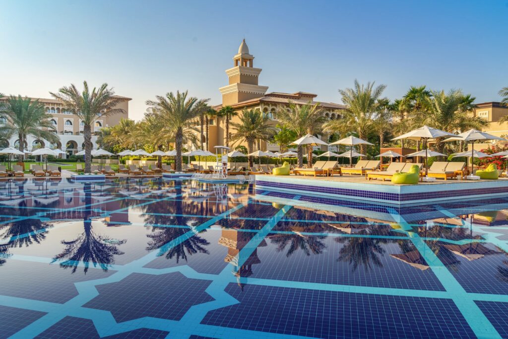 a pool with palm trees and umbrellas