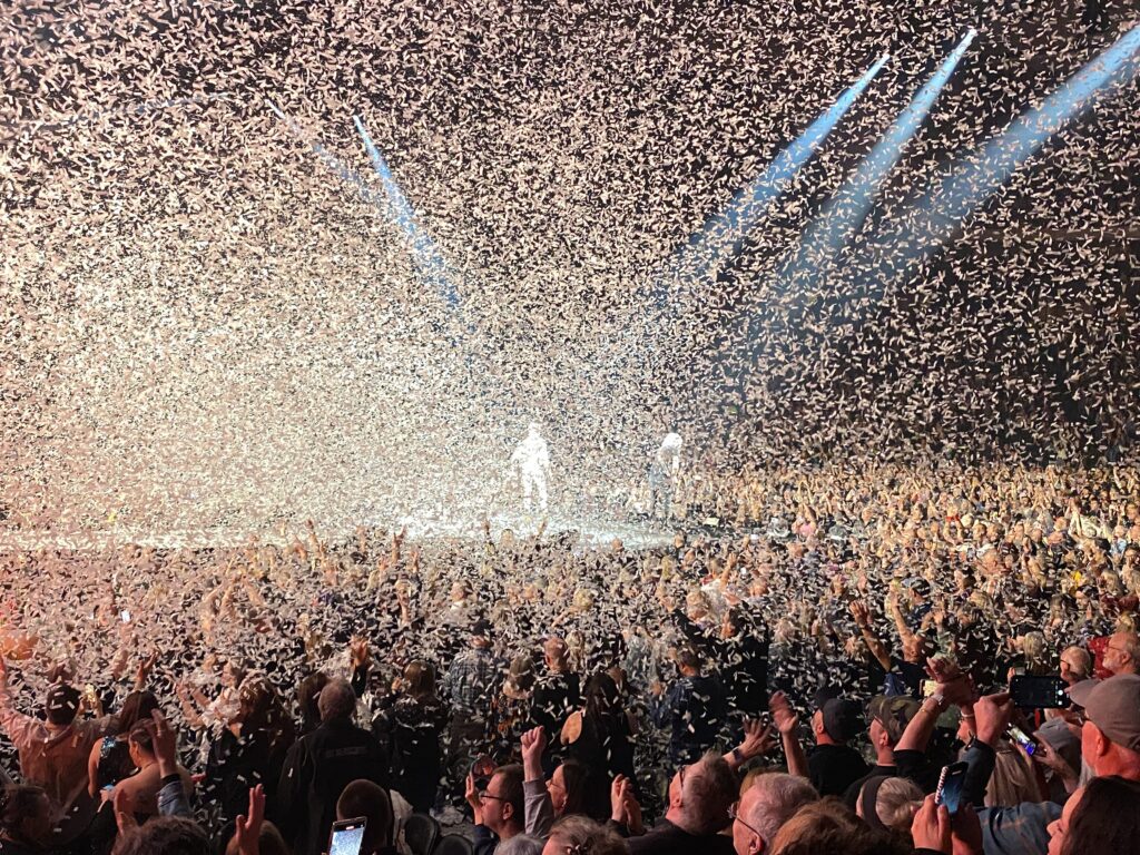 a crowd of people in front of a stage with confetti