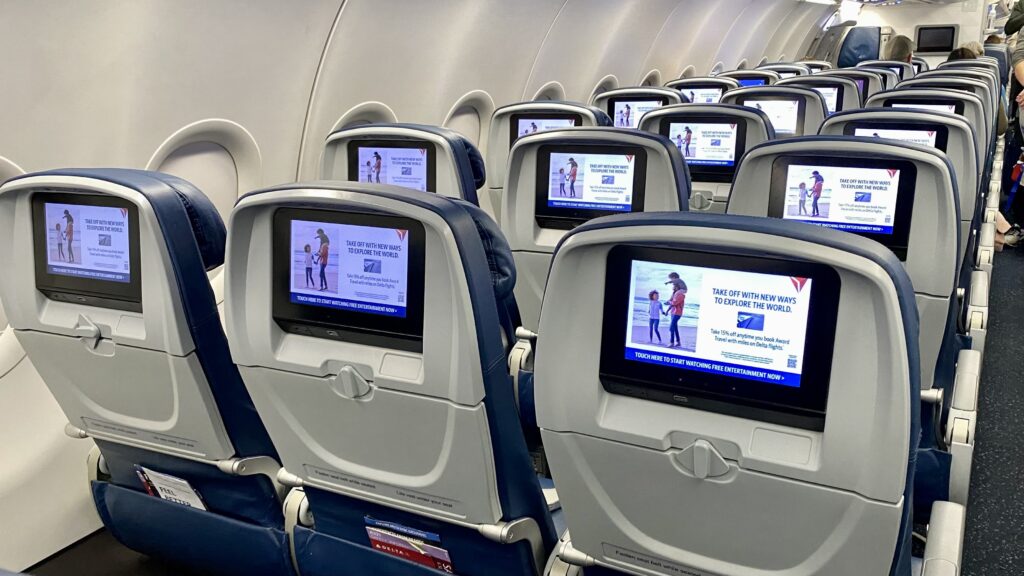 a row of seats with monitors on the back