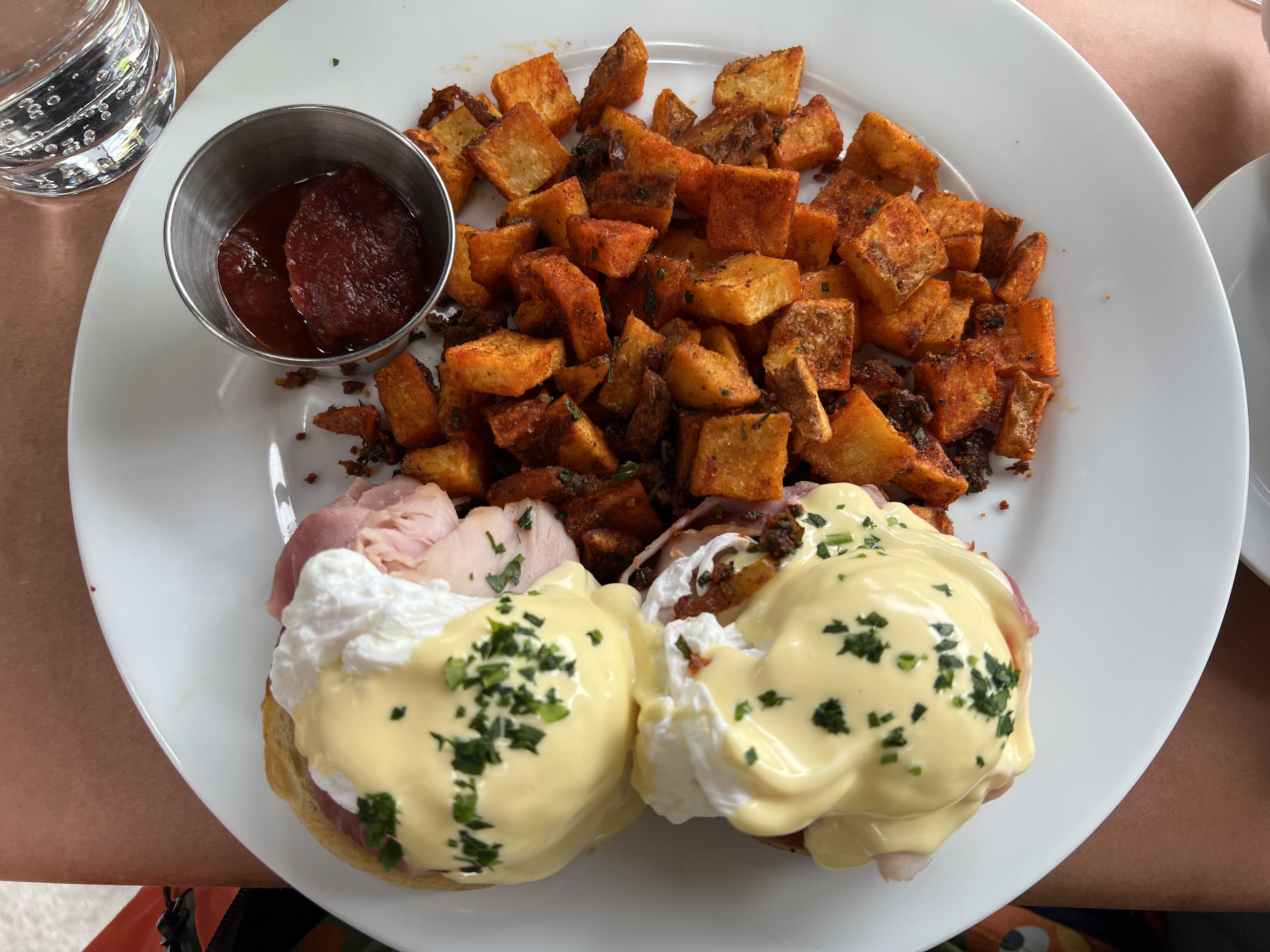 a plate of food with a sauce and a cup of ketchup