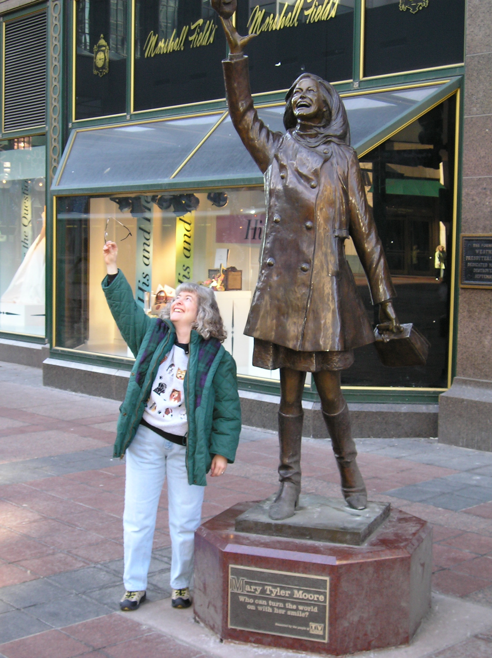 a woman standing next to a statue