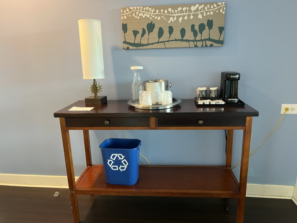 a table with a coffee maker and a lamp