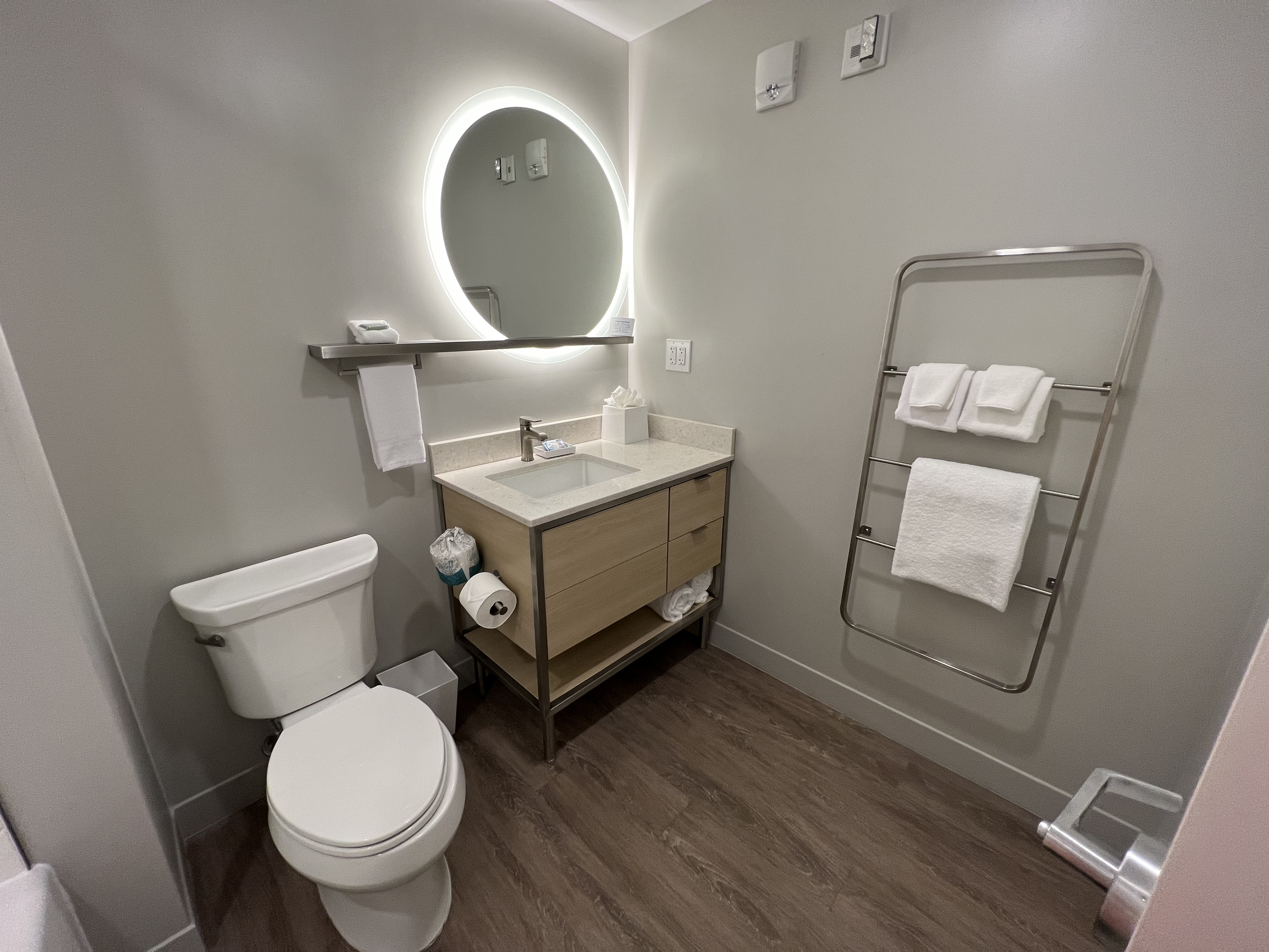 a bathroom with a round mirror and a sink