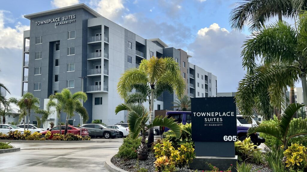 a building with palm trees and a parking lot