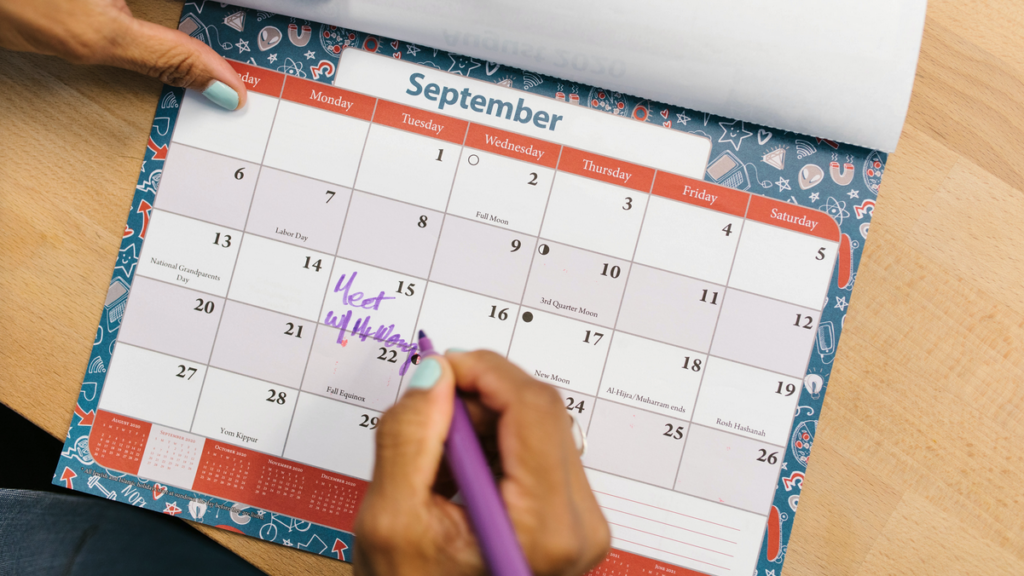 a person writing on a calendar