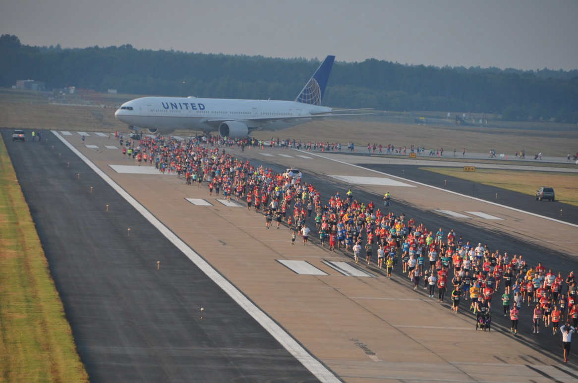 a group of people running on a runway