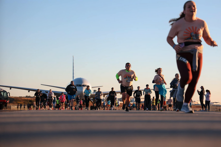 a group of people running on a runway