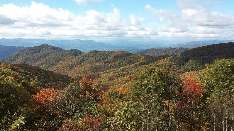 a landscape of a mountain range with trees and mountains in the background