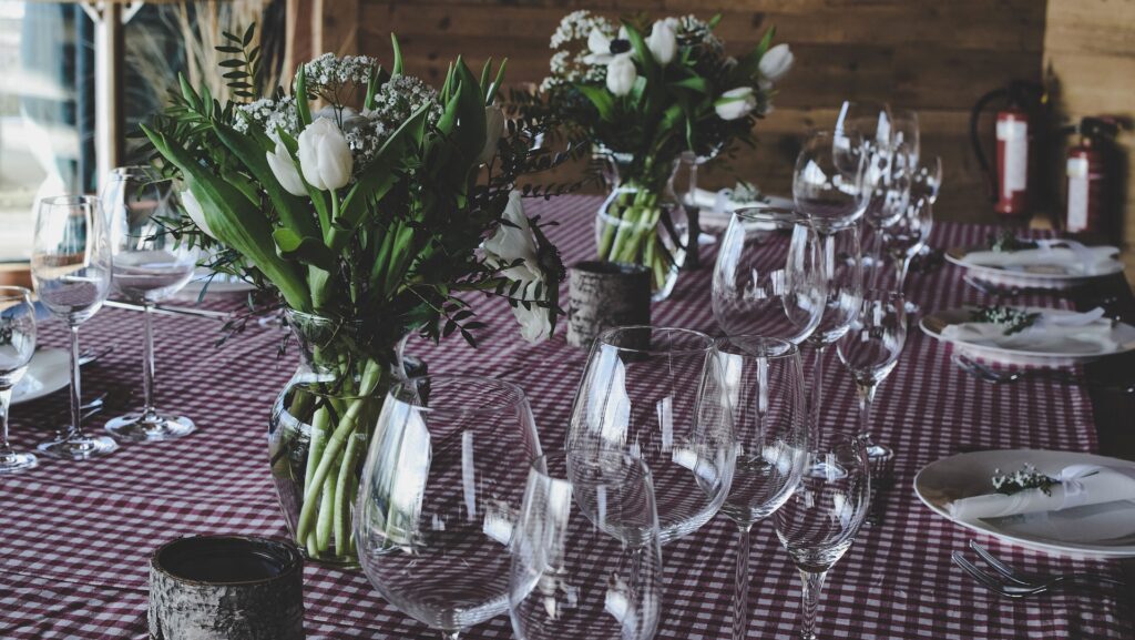 a table with wine glasses and flowers