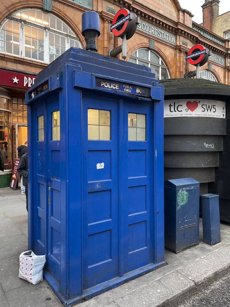 a blue police box on a sidewalk