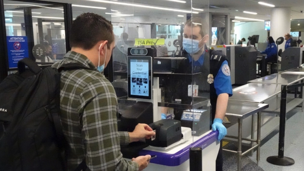 a man wearing a mask and gloves at a check-in counter