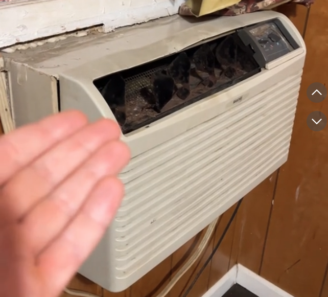 a hand reaching out to a air conditioner