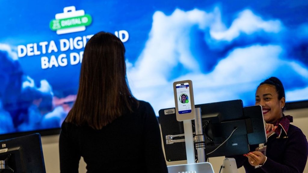 a woman standing in front of a large screen