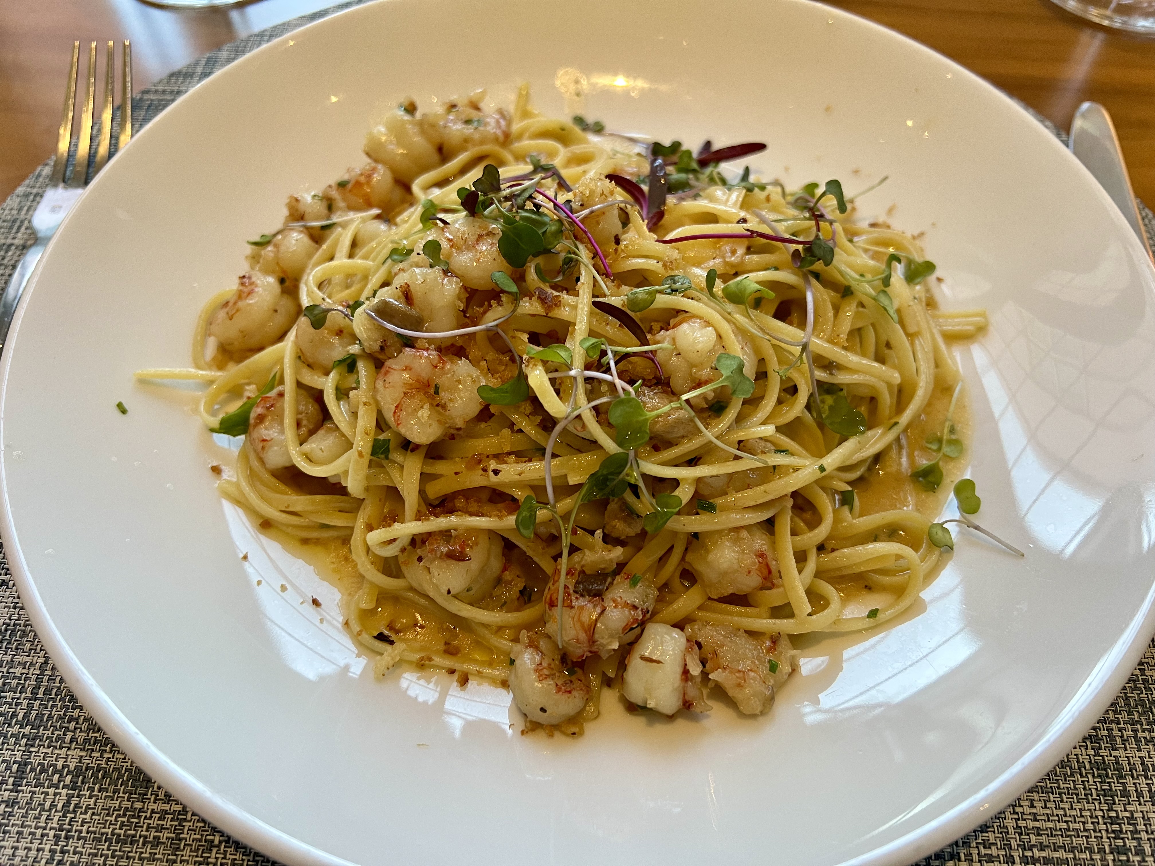 a plate of pasta with shrimp and herbs