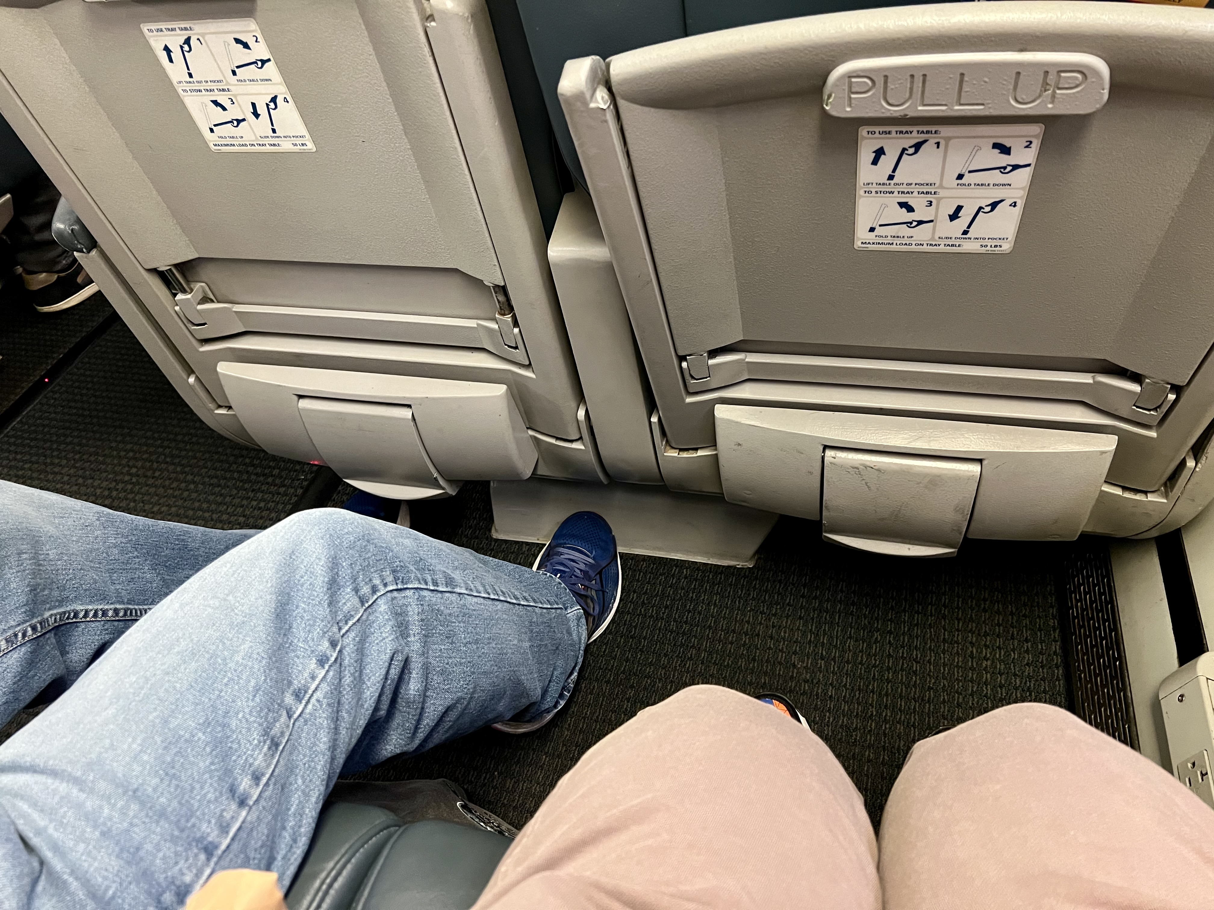 a pair of people's legs in an airplane