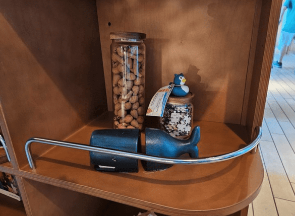 a shelf with a blue toy and a jar of nuts