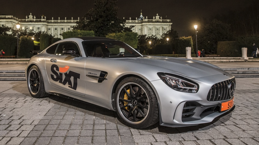 a silver sports car parked on a brick surface