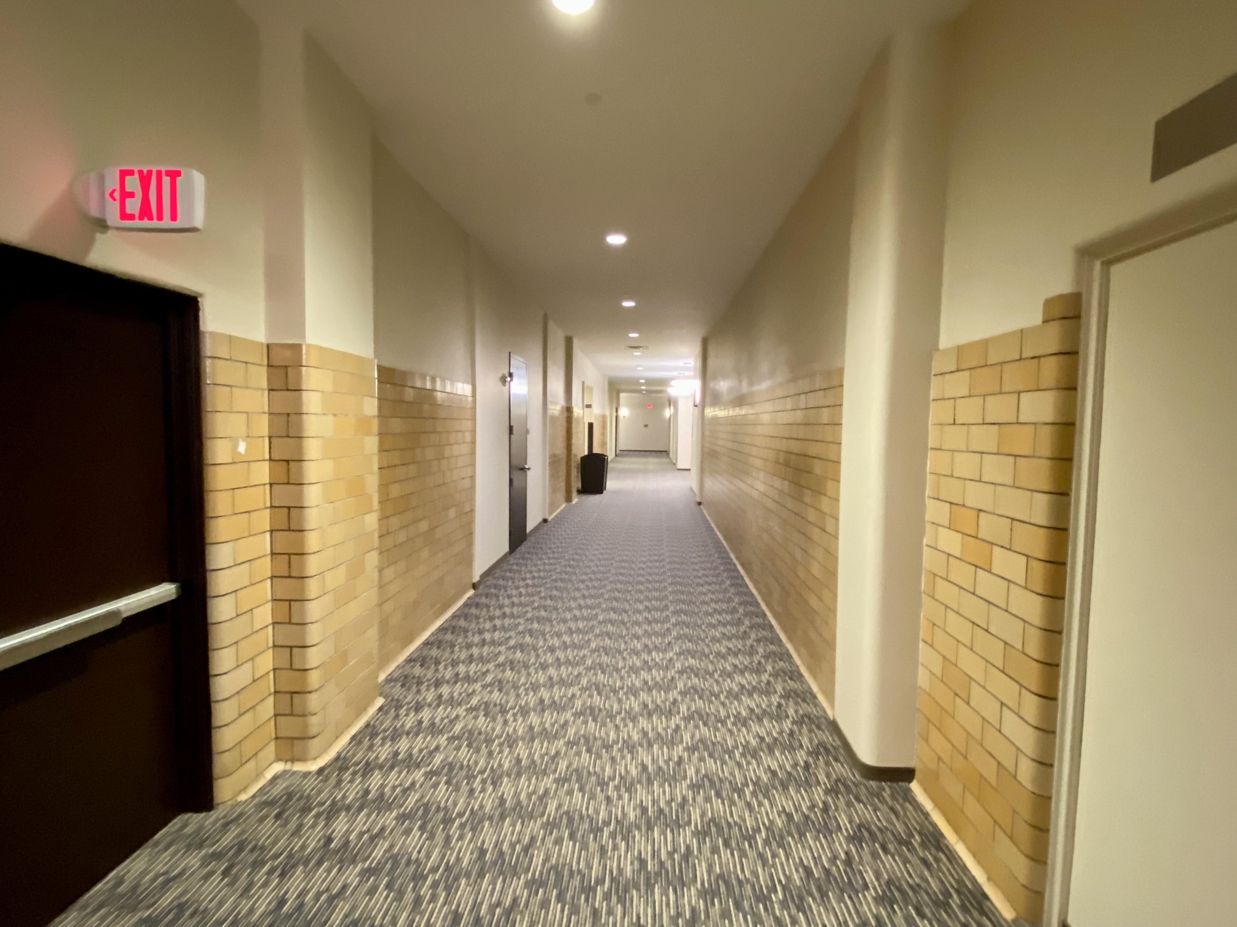 a hallway with brick walls and a door