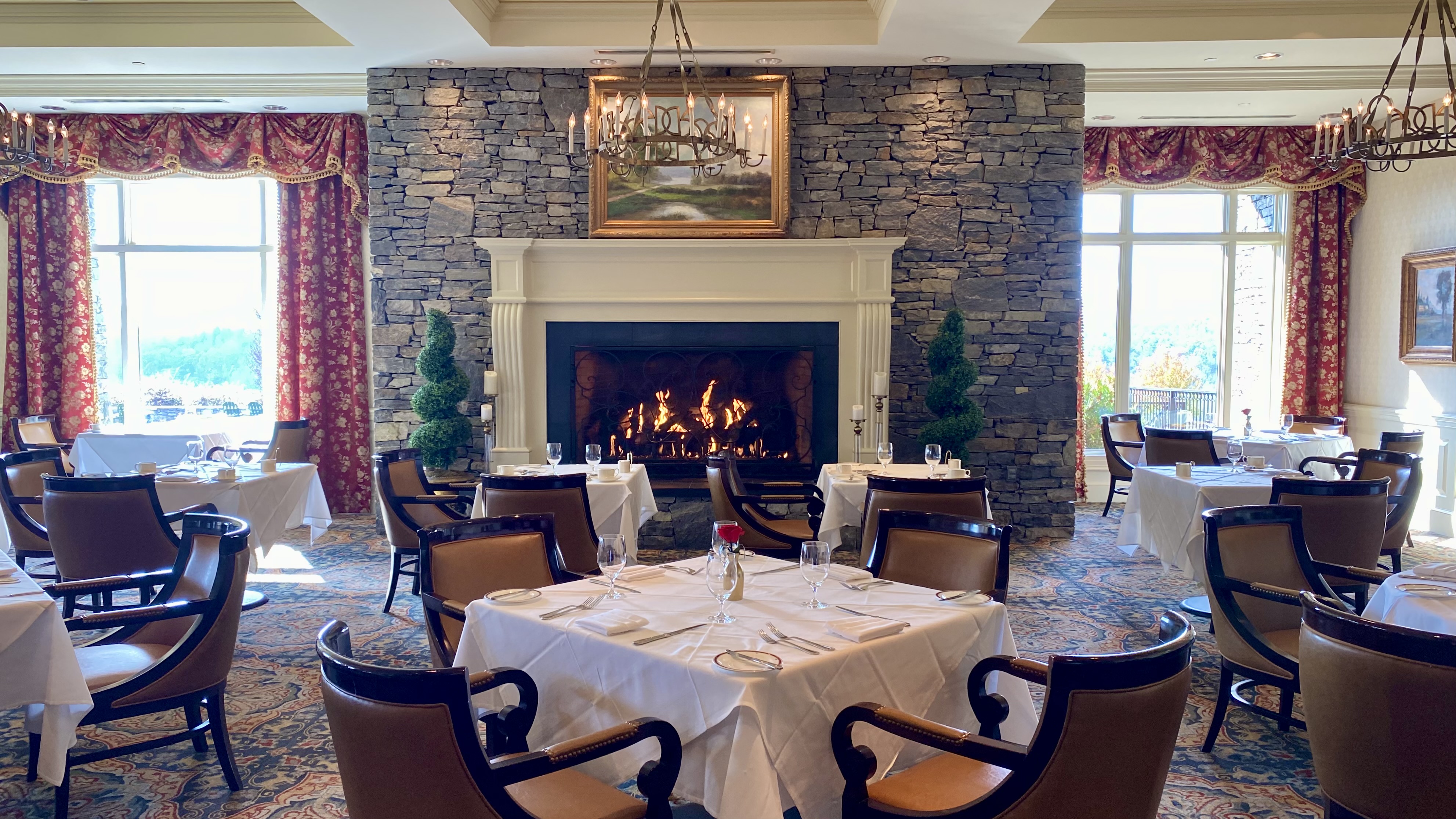 a room with a fireplace and tables and chairs