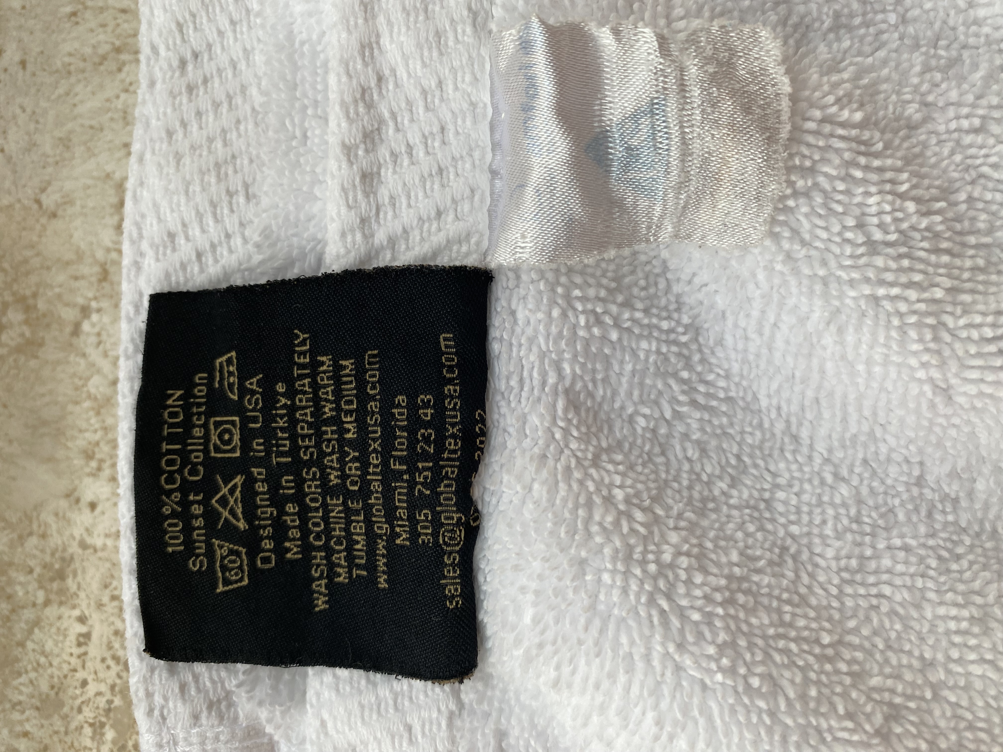 a black and gold label on a white fabric