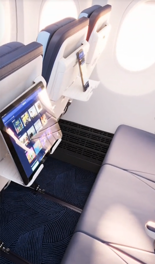 a tablet and phone on a shelf in an airplane