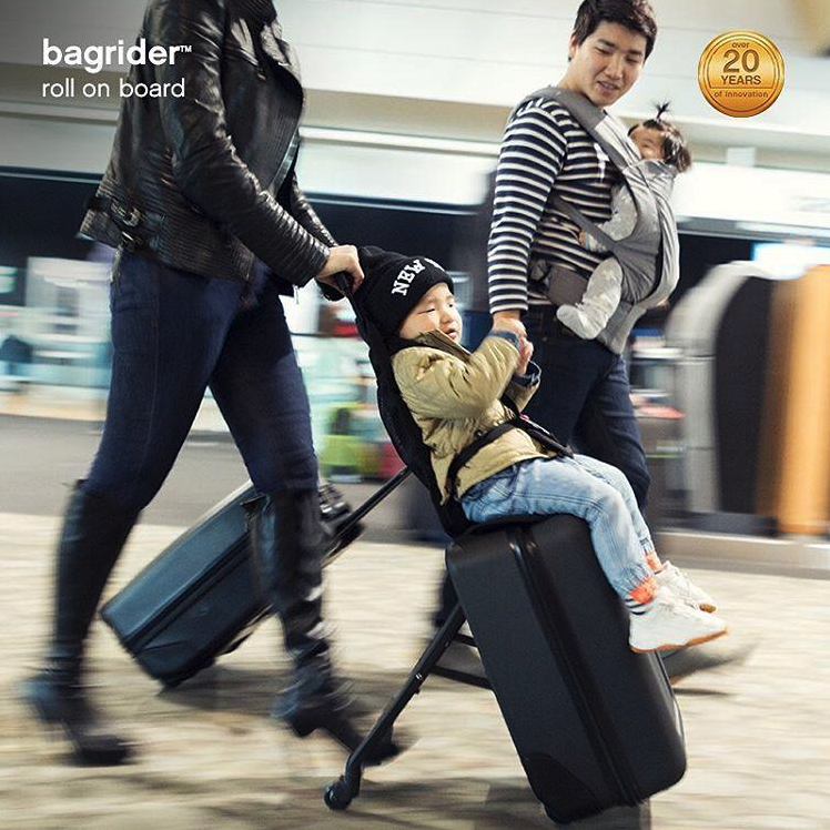 a man pushing a child on a luggage
