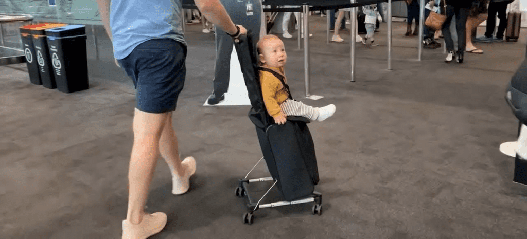 a baby sitting in a luggage seat