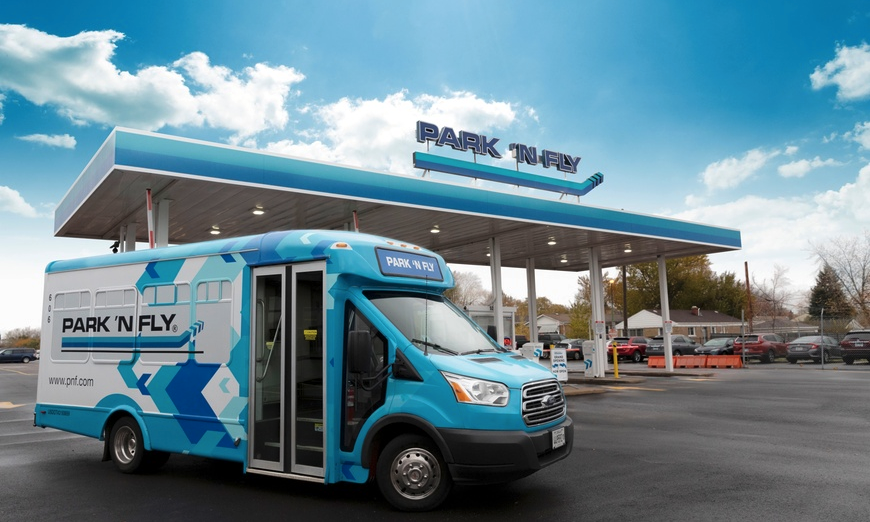 a blue bus parked in front of a gas station