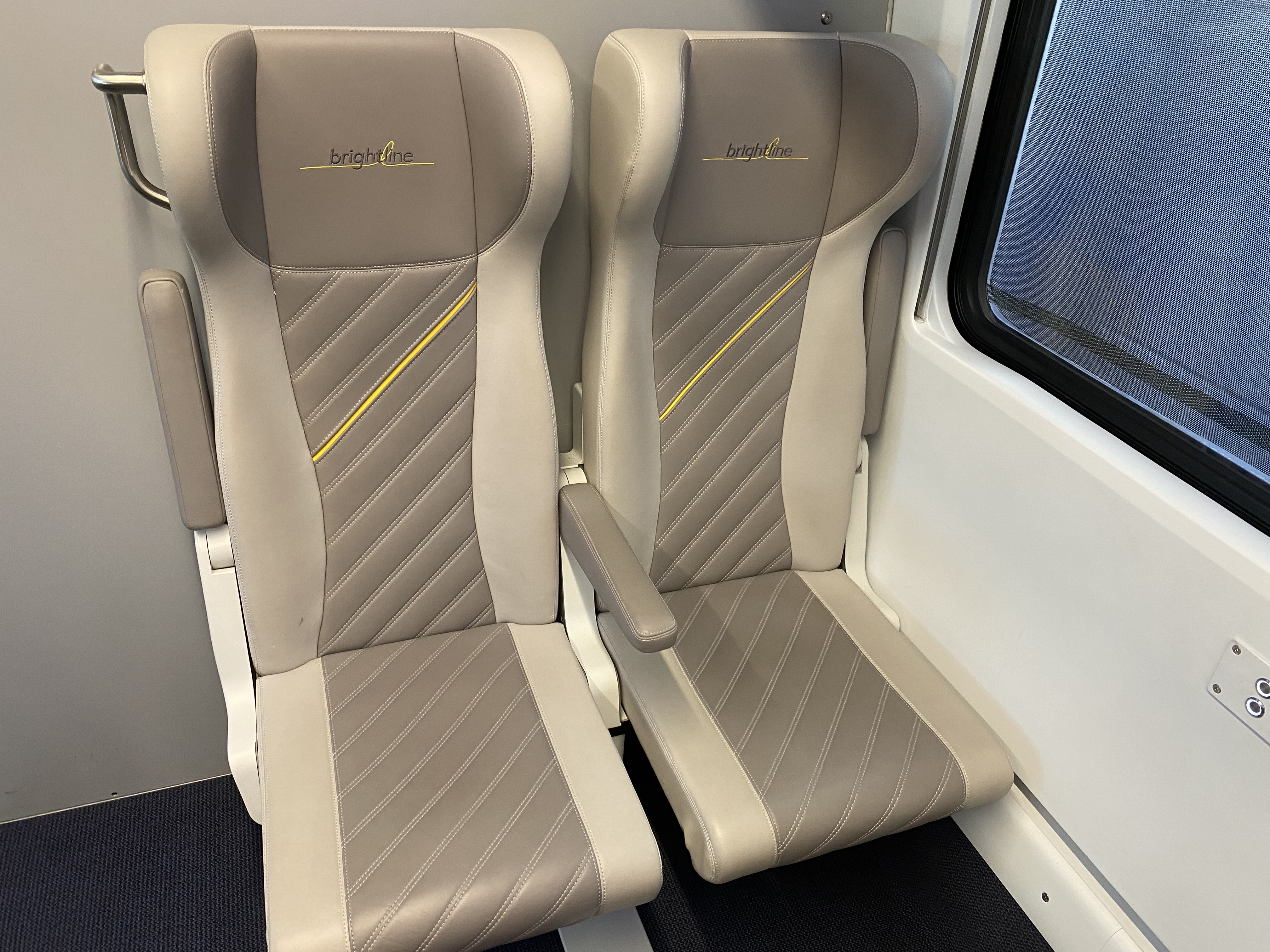 a pair of beige seats in a train