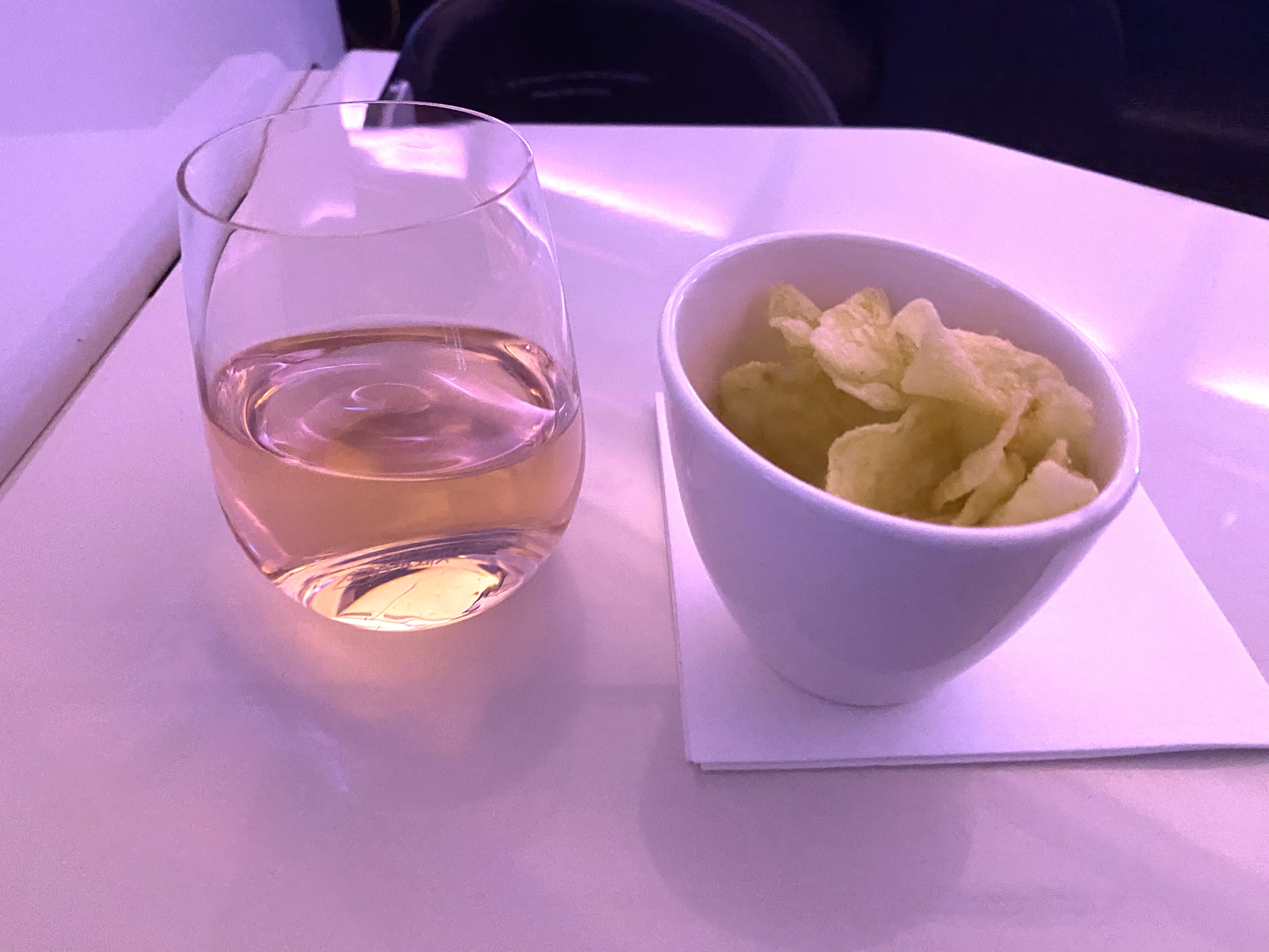 a glass of wine and a bowl of potato chips