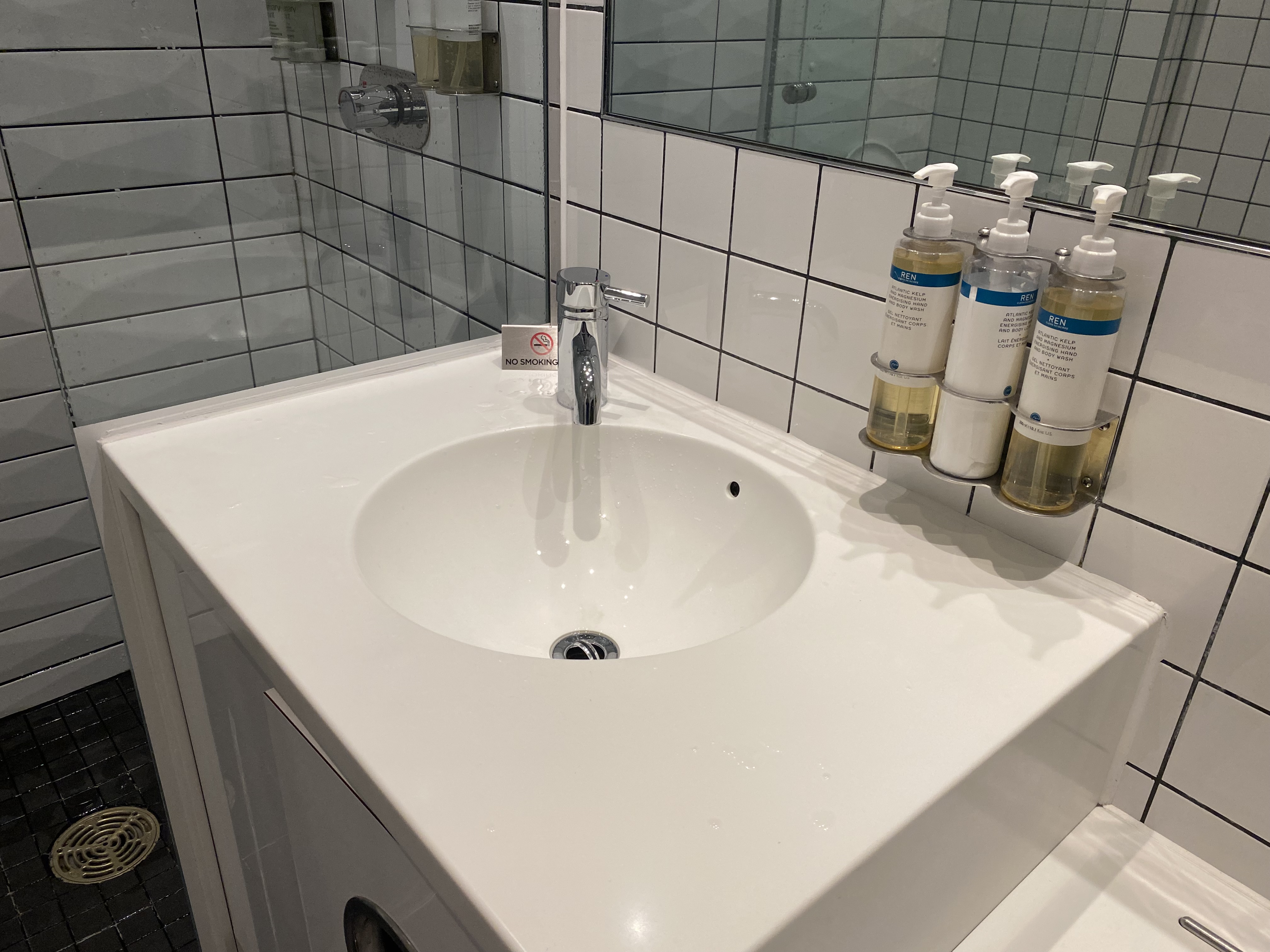 a sink with soap dispensers on the wall