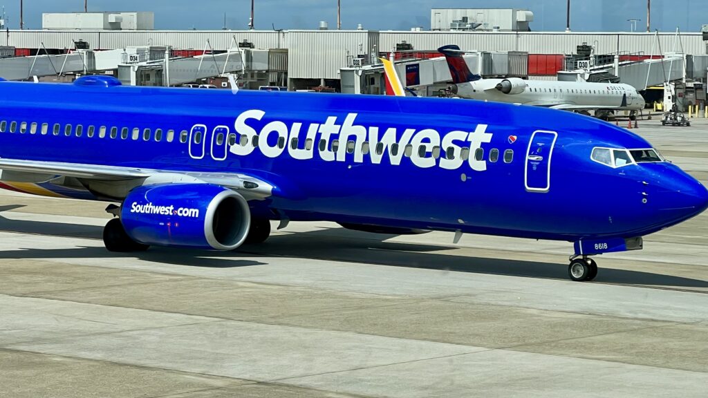 a blue airplane on a runway