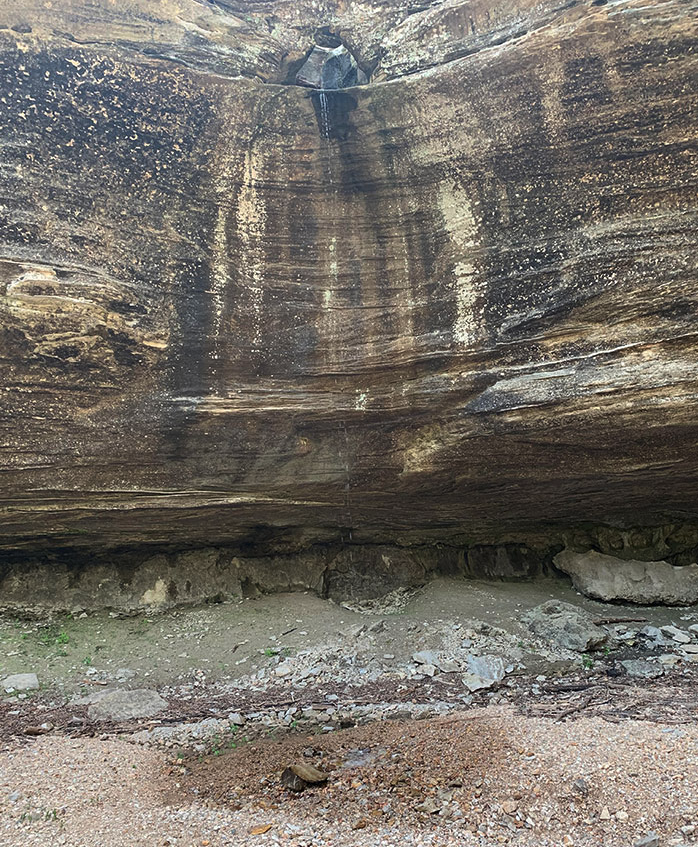 a rock wall with a waterfall