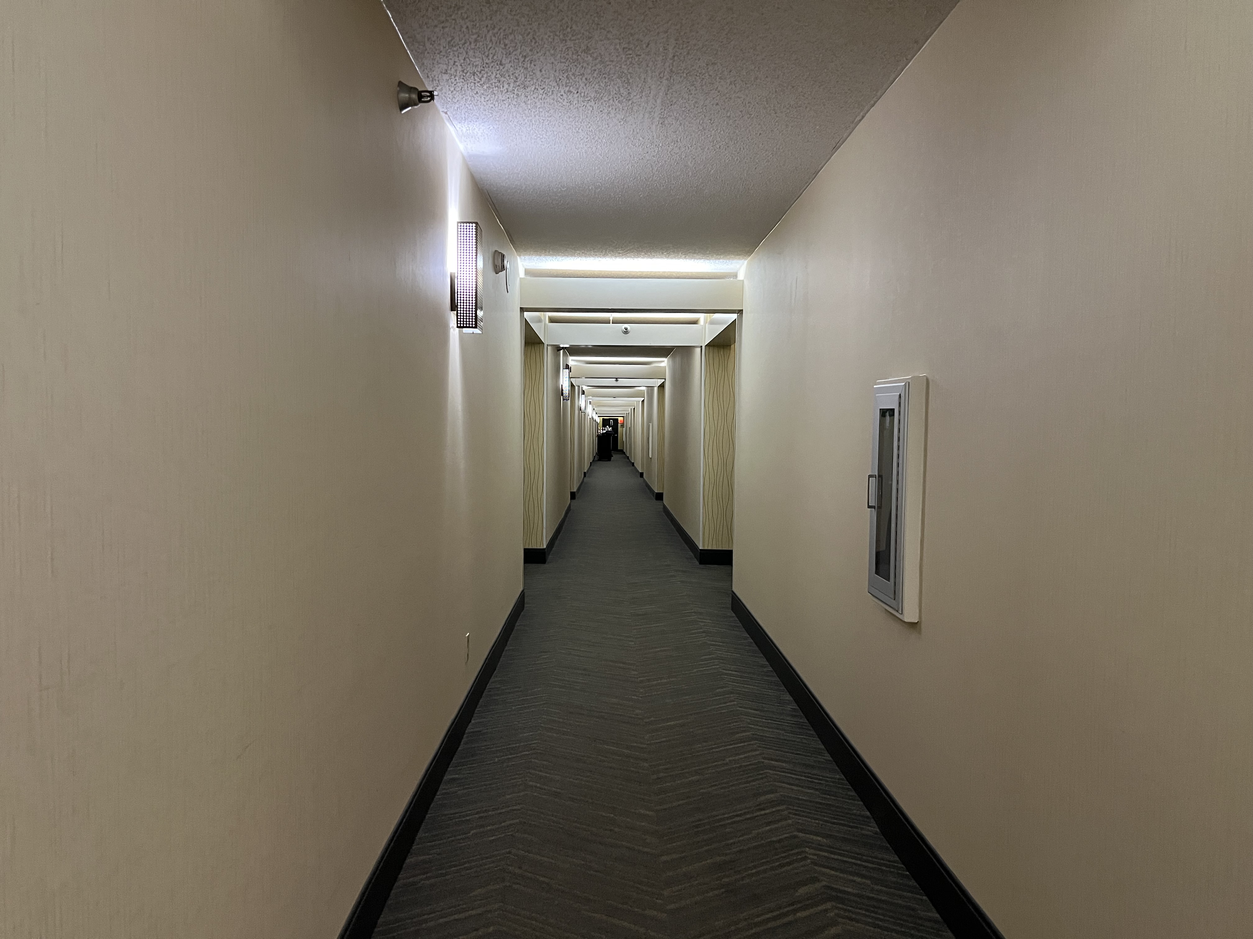 a long hallway with lights and a few boxes on the wall