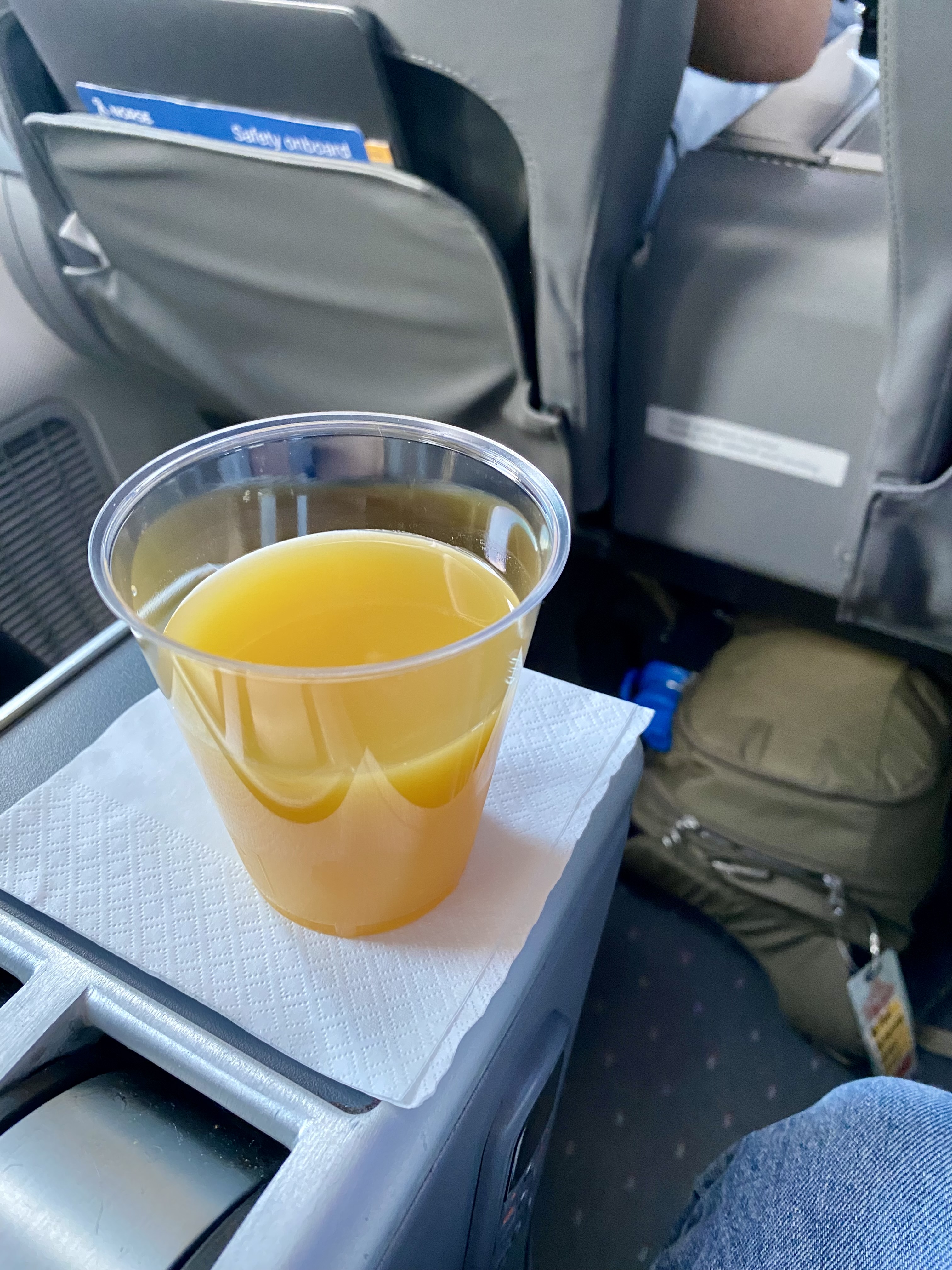 a cup of orange juice on a napkin