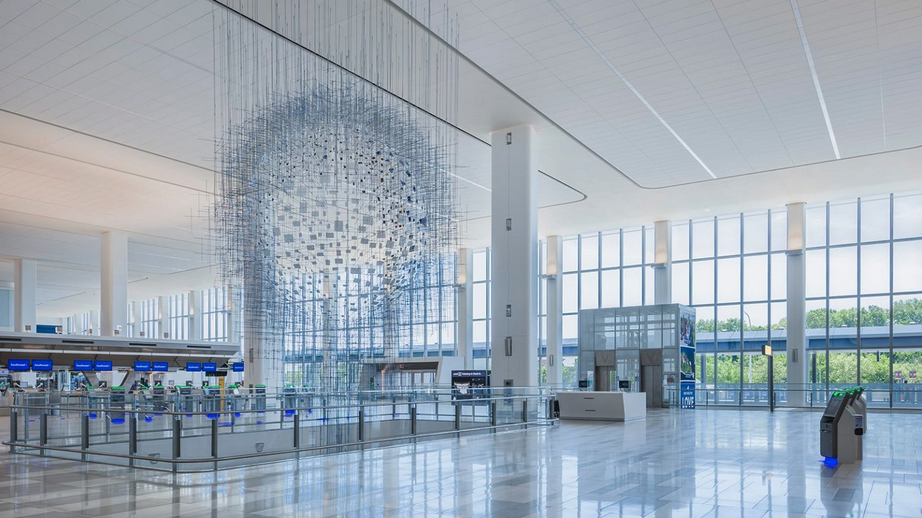 a large white building with glass walls and a large white sphere