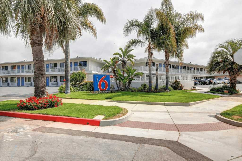 a building with palm trees and a sign