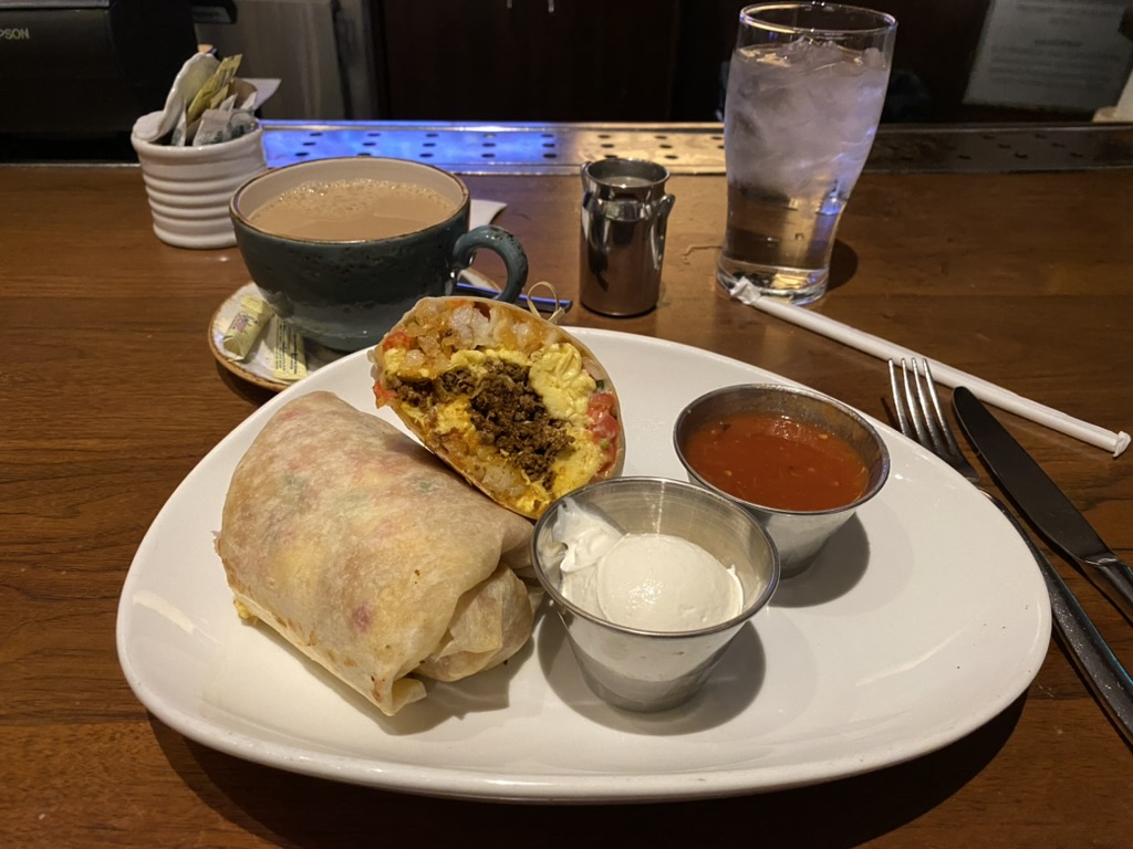 a plate of burritos and cups of coffee