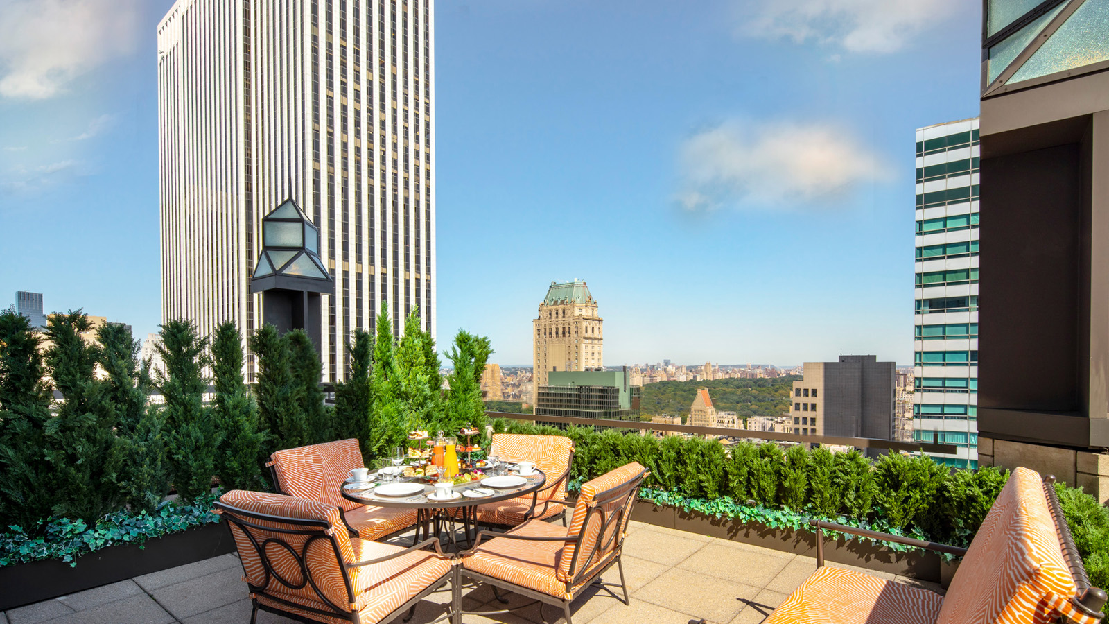 a table and chairs on a rooftop overlooking a city