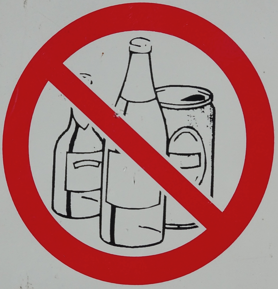 a sign with a red circle and a red circle with a drawing of bottles and cans