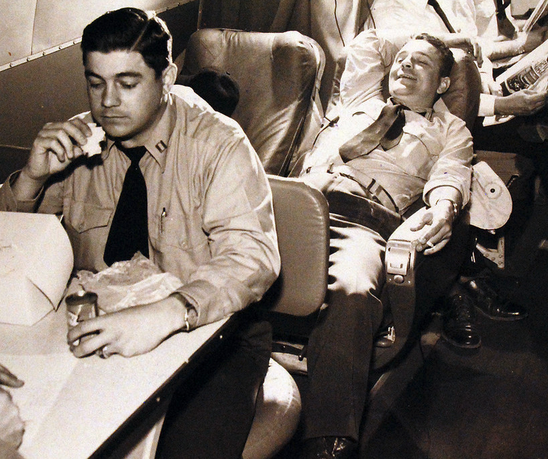 a couple of men sleeping in an airplane