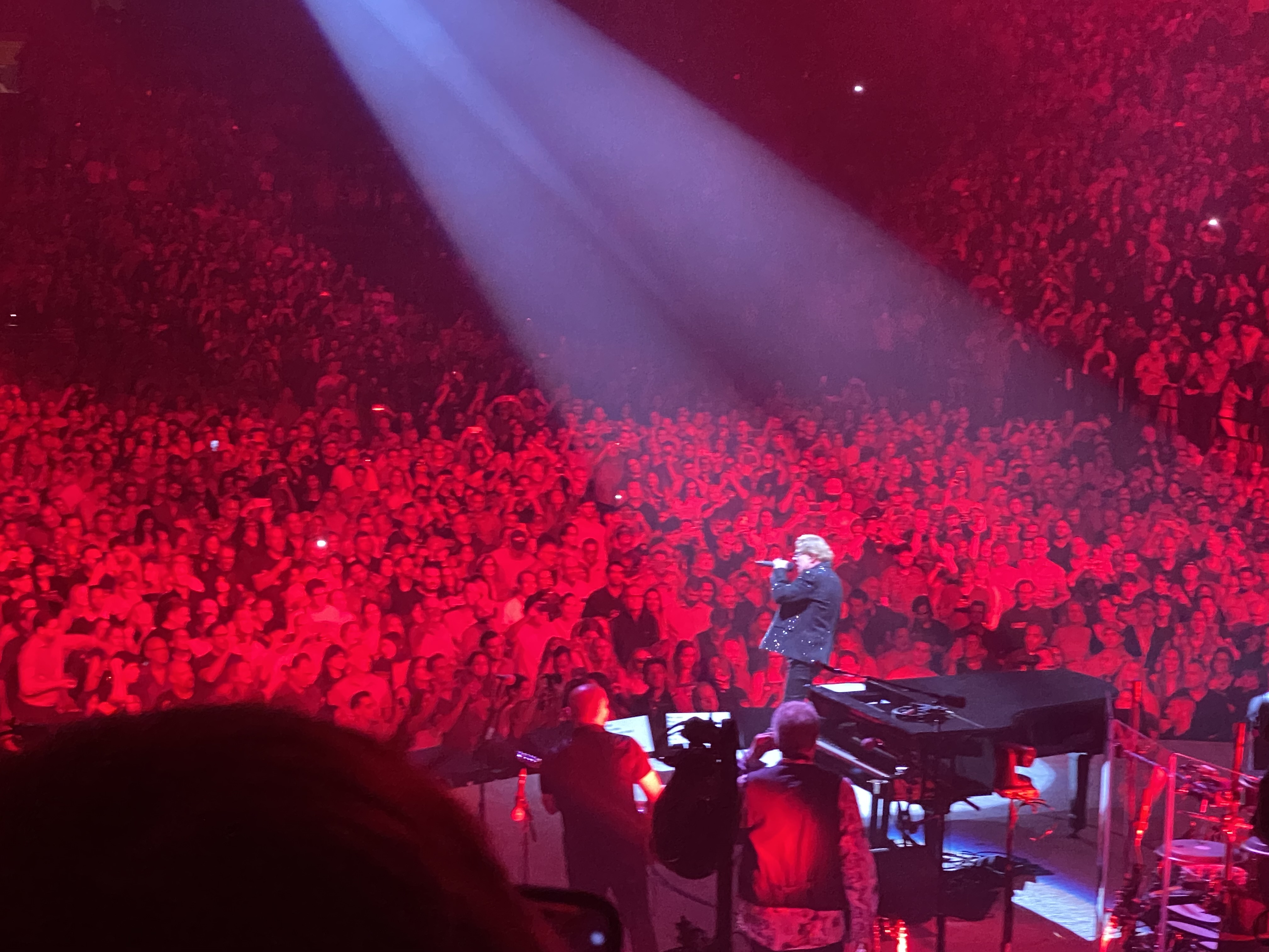 a man on stage with a crowd of people watching