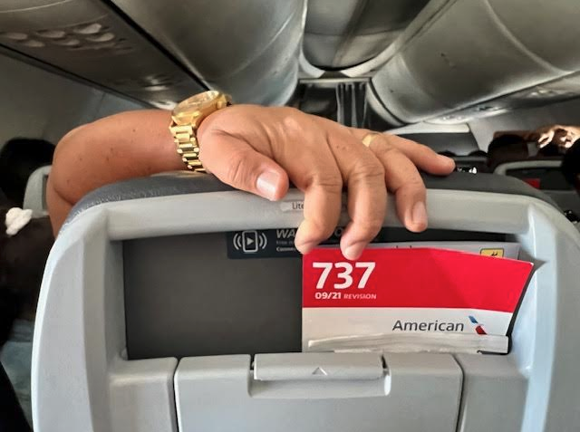 a person's hand on a luggage compartment