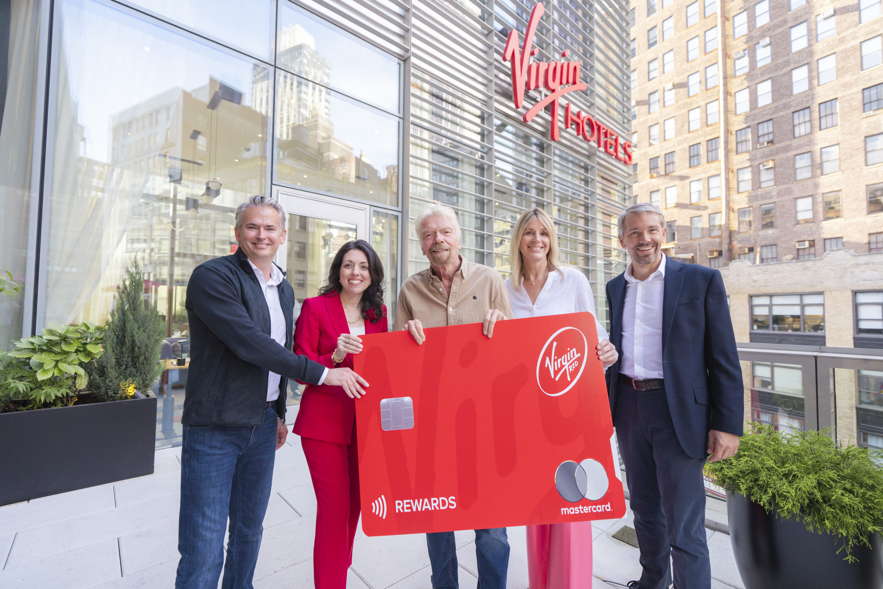 a group of people holding a large red card